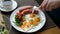 Man eating breakfast. Knife and fork in hand. American style breakfast with fried eggs, sausage, salad and toast.