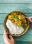 Man eating cauliflower spicy curry rice top view