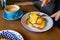 Man eating eggs benedict with knife and fork close-up.