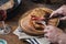 Man is eating grilled steak at a wooden table