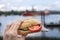 Man eating typical North German fish bun with herring, onions, cucumber and a tomato