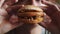 Man eats burger filled with larvae maggot, front view, closeup. Man is eating an exotic hamburger with maggots. Concept