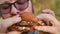Man eats eating hamburger outdoors. Close-up