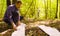 The man ecologist examining the plants inside the square marking site.