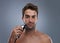 Man, electric shaver and studio portrait for grooming, skincare and happy for wellness by grey background. Person, model