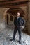 Man in elegant clothes poses under the arcades