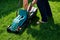 Man empties the lawnmower on a green meadow