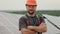 Man energy technician in uniform smiling while standing at solar power farm. Portrait of male engineer in protective