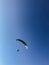 A man is engaged in paragliding. Parachute in the blue sky.