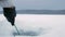 The man is engaged in winter fishing on a frozen lake. Clears the hole on the ice crust.