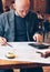 Man engineer designer architect reading drawings at table in cafe