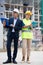 Man engineer standing on a construction site with a young woman worker monitors the construction plan on a laptop