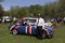 Man in English policeman uniform standing next to classic car painted in UK flag colours