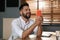 Man enjoying air flow from portable fan at workplace.