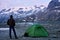 Man enjoying mountains scenery near tent.