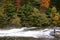 A man enjoying the nature scene of river rapid in autumn