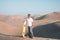 Man enjoying sand boarding at Huachina desert sand dunes Peru South America