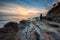 Man enjoying the sunrise at a picturesque rocky beach