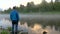 Man enjoys clear lake with morning fog and reflecting sky