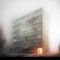 Man entering a creepy residential building on a misty day. Red light glowing at the entrance, eerie ambience. Generative AI