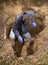 Man Examining Old Clay Ceramic Pipe Sewer Line in Hole in Ground