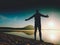 Man exercising on beach. Silhouette of active man exercising and stretching at lake