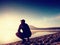 Man exercising on beach. Silhouette of active man exercising and stretching at lake