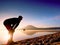 Man exercising on beach. Silhouette of active man exercising and stretching at lake