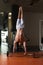 Man Exercising Handstand Push-Ups On Barbell In Gym