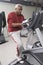 Man Exercising On Stationary Bike In Health Club