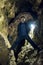 Man exploring huge cave. Adventure travellers dressed. extreme vacation, tourist route. ancient crystal formations, geology,
