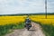 Man extreme sport riding touring enduro motorcycle on dirt. beautiful yellow field of flowers. World adventure rider. Tourist bike