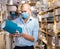 Man in face mask choosing table lamps in store