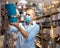 Man in face mask choosing table lamps in store