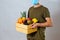 Man with face mask giving wooden box with fruit and vegetable to customer