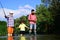 Man family fishing. Boy with father and grandfather fly fishing outdoor over river background. Old and young. Father and