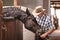 Man, farmer and feeding a horse in stable for care with bonding, support and help in Texas. Mature, male person and