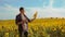 Man farmer hand lifestyle hold bottle of sunflower oil the field at sunset. slow motion video. man farmer agriculture