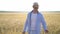 Man farmer in a hat walking in wheat field