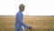 Man farmer in a hat walking in wheat field