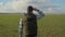 Man farmer red neck in a cap is walking on a green field. harvest agriculture concept. male walks on winter wheat green