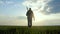 Man farmer silhouette red neck holding a shovel lifestyle in his hand walking across the field a pile of dirt soil. Eco