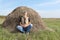 Man farmer sitting in a field near a haystack