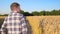 Man farmer walking down golden Barley field