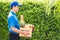 Man farmer wears delivery uniform he holding full fresh vegetables and fruits in crate wood box