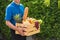 Man farmer wears delivery uniform he holding full fresh vegetables and fruits in crate wood box