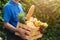 Man farmer wears delivery uniform he holding full fresh vegetables and fruits in crate wood box