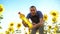 Man farmer working holding in hand a plastic bottle sunflower oil stands in the field. slow motion video. sunflower oil
