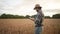 Man farmer working in tablet at the field wheat inspects the crop