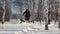 Man fast riding on mini snowmobile on deep snowdrifts in the forest and maneuvering between the trees